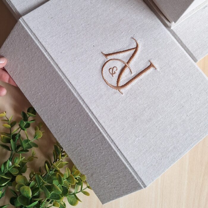 caixa cartonada revestida em tecido com fechamento em imã e iniciais bordadas